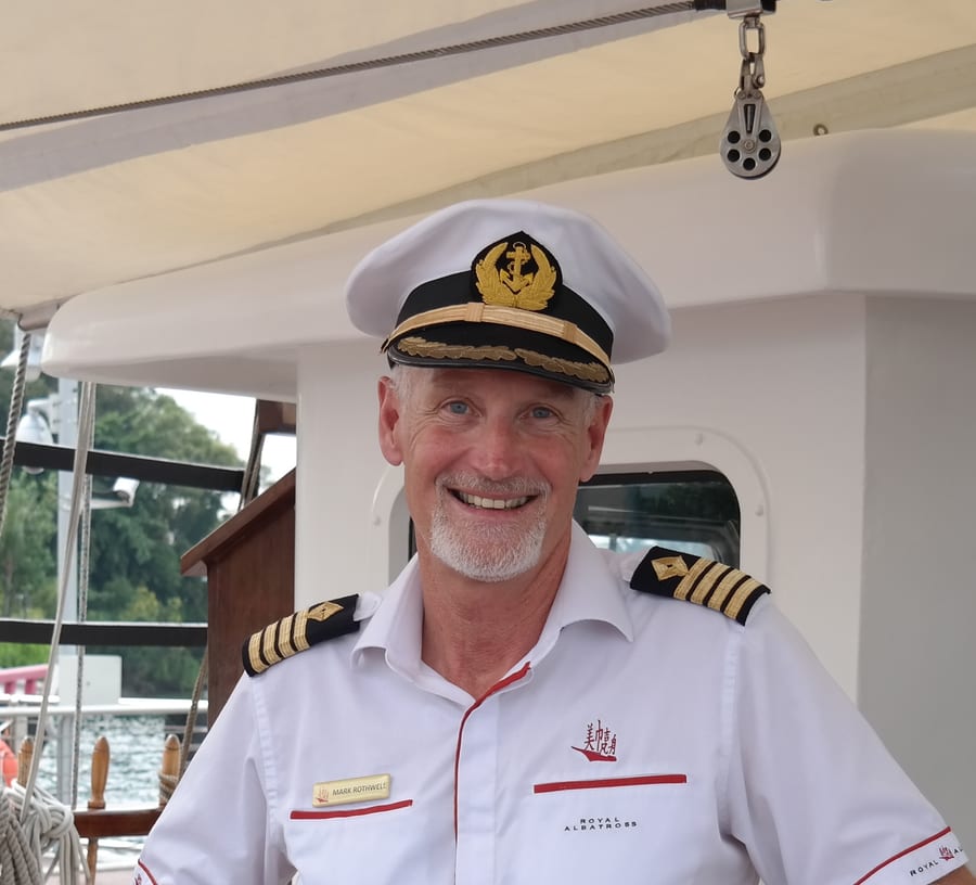 Mark Rothwell in captain's uniform on board a sailing vessel