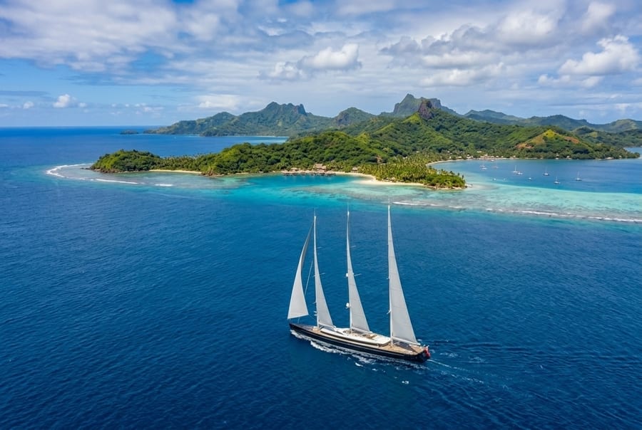 The 81 metre three-masted sailing superyacht Sea Eagle under sail off islands in Fiji